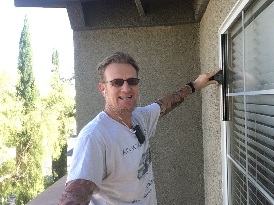 Al running a squeegee across a home window